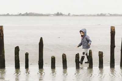 Boy walking on cold winter beach