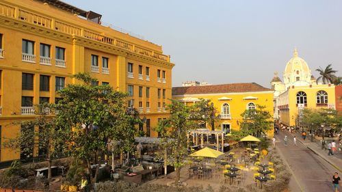 High angle view of yellow buildings in city against sky