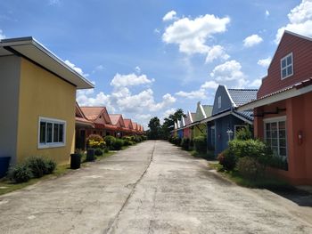 Street amidst houses and buildings against sky