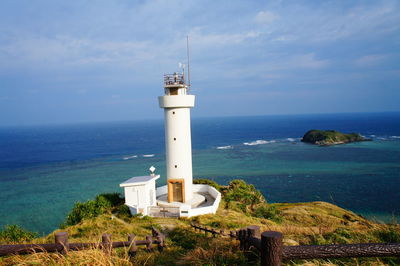 Lighthouse by sea against sky