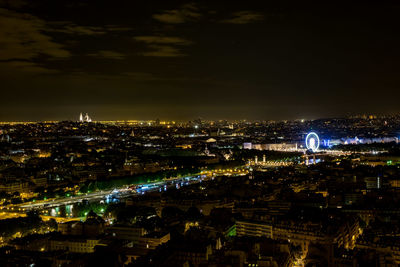 Illuminated cityscape against sky at night