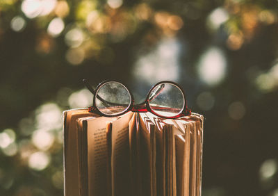 Close-up of sunglasses against blurred background, glasses on book, reader 