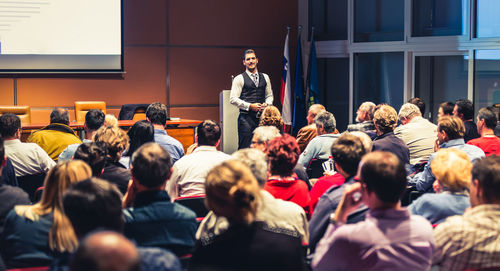 Business speaker giving a talk at business conference meeting event.