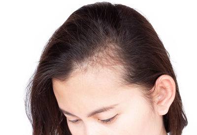 Close-up portrait of a young woman over white background