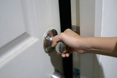 Close-up of woman holding glass door at home