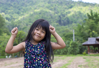 Portrait of a adorable little asian girl smiling looking at camera with a natural background. 