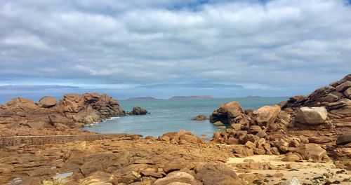 Scenic view of rocks on beach against sky