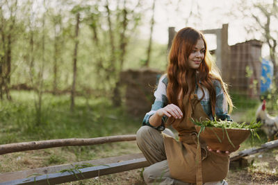 Portrait of smiling young woman looking at park