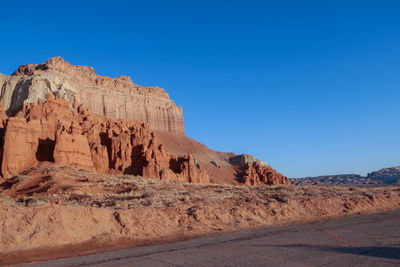 Rock formations in desert against clear blue sky