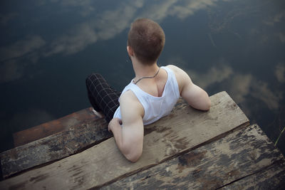 Rear view of woman sitting on wood