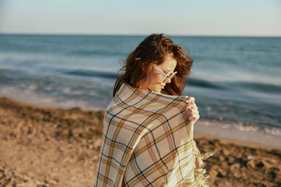 Rear view of woman standing at beach