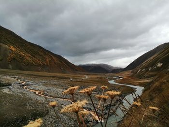 Scenic view of land and mountains against sky