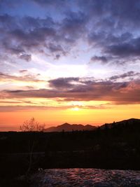 Silhouette landscape against sky during sunset