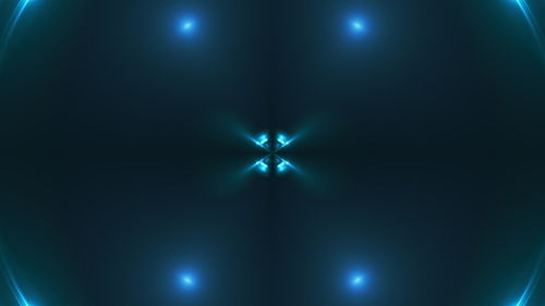 Close-up of illuminated lighting equipment against blue background