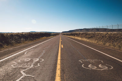 Road by landscape against clear sky