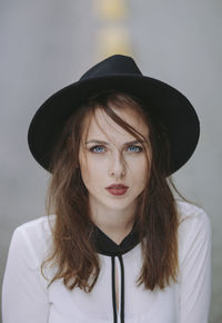 Portrait of blue eyed young woman wearing black hat