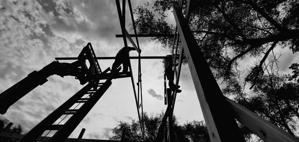 Low angle view of silhouette rollercoaster against sky