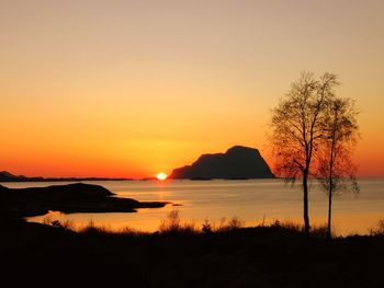 Scenic view of lake against orange sky