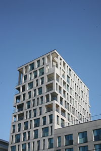 Low angle view of modern building against clear blue sky