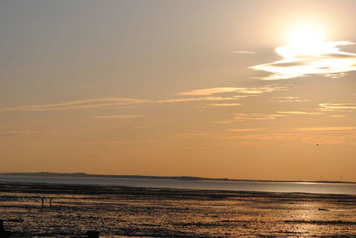 Scenic view of sea against cloudy sky during sunset