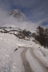 Snow covered land against sky