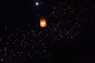 Low angle view of illuminated lantern against sky at night