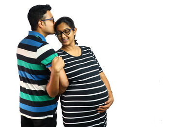 Young couple kissing against white background