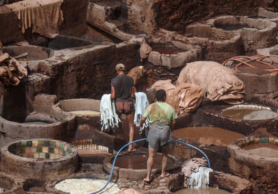 Rear view of men working on rock