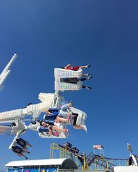 Low angle view of amusement park ride against blue sky