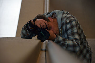 Close-up of mature man holding camera at home