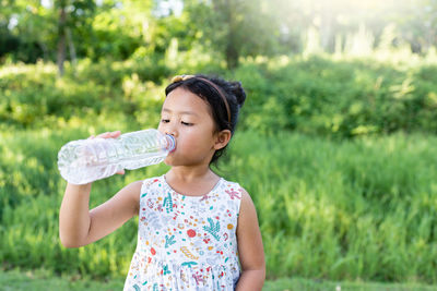 Young woman drinking water bottle