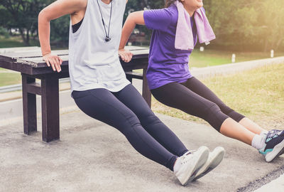 Low section of female friends exercising at park