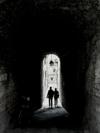 Silhouette man standing in tunnel