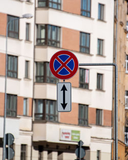 Close-up of road sign against buildings in city