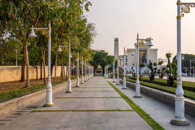 Footpath by street against sky in city