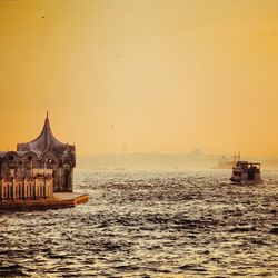 Boat sailing in sea at sunset