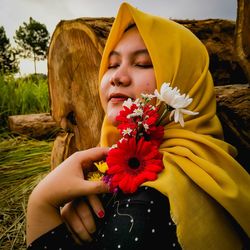 Midsection of woman holding yellow flowering plant