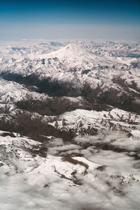 Aerial view of snowcapped mountains against sky