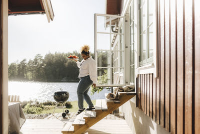 Young woman with food moving down on steps during party