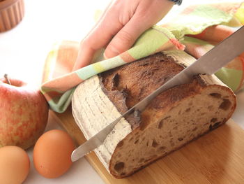 Close-up of hand holding bread on table