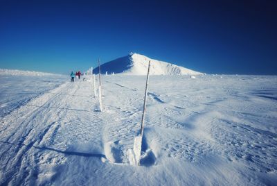 People skiing on snowcapped mountain against sky