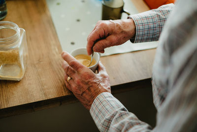 Midsection of person preparing coffee at home