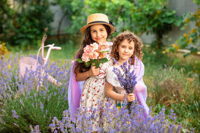 Portrait of smiling young woman standing amidst plants