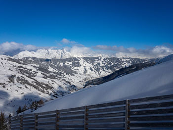 Scenic view of snowcapped mountains against blue sky