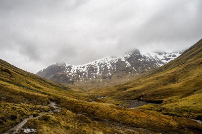 Scenic view of mountains against cloudy sky