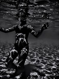 Rear view of man swimming in sea