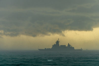 Ship sailing in sea against sky during sunset