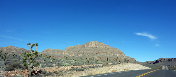 Scenic view of mountains against blue sky