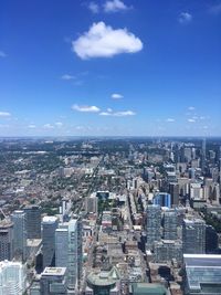 High angle view of buildings in city against blue sky
