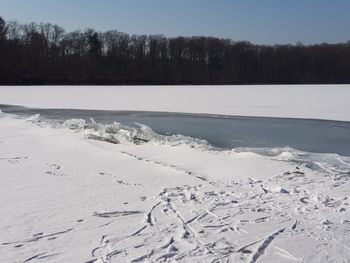 Scenic view of frozen lake against sky during winter